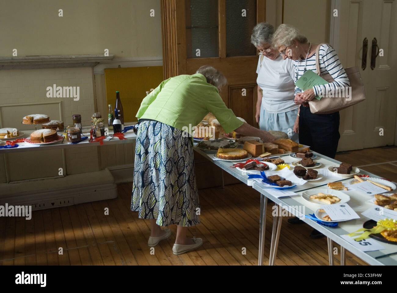 Hausgemachte Kuchen Wettbewerb UK. Sommerfest des Dorfes. Drei ältere Frauen überprüfen die Qualität der Kuchen. Sie sind die Richter. Petersham Richmond 2011 2010er Jahre, Großbritannien HOMER SYKES Stockfoto