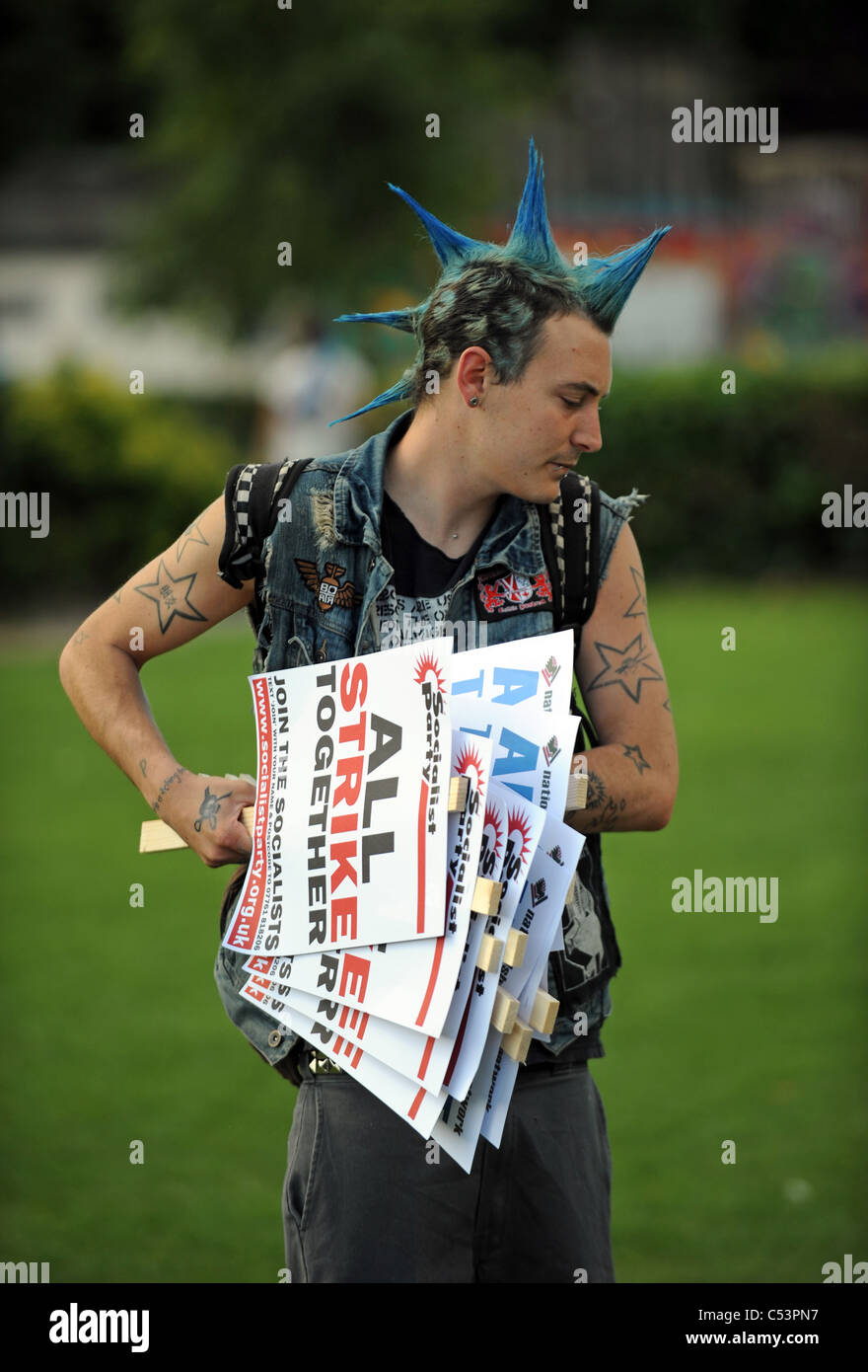 Mann mit blauen Punk-Stil Mode Haare halten Banner am Protest gegen die Regierung Kürzungen bei Renten der Lehrer und Mitarbeiter Stockfoto