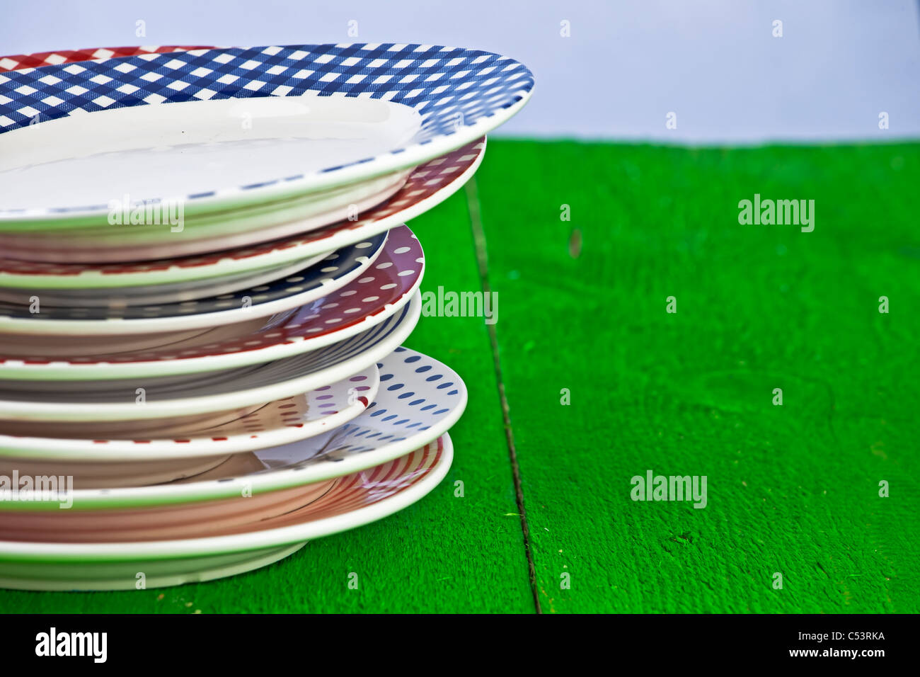 rustikal und bunte Platten auf einem grünen Holztisch Stockfoto