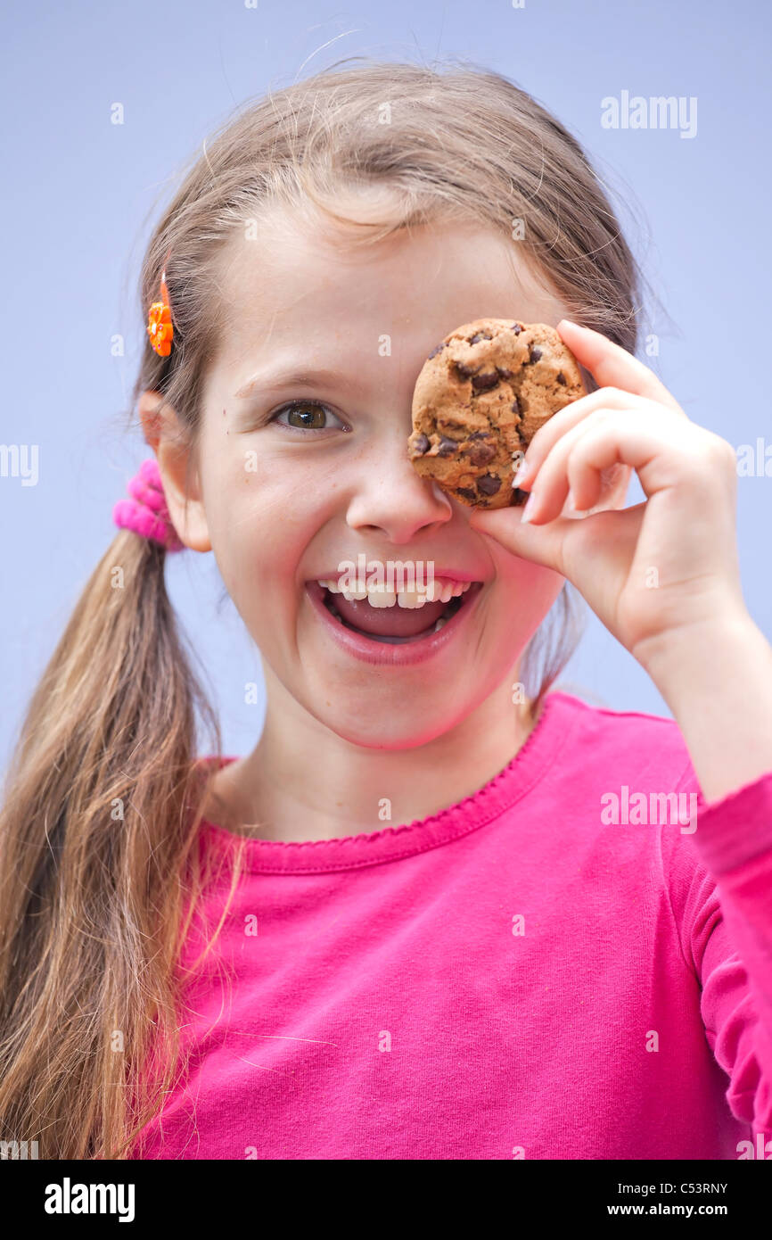 ein sieben-jährige Mädchen essen Schokolade cookies Stockfoto