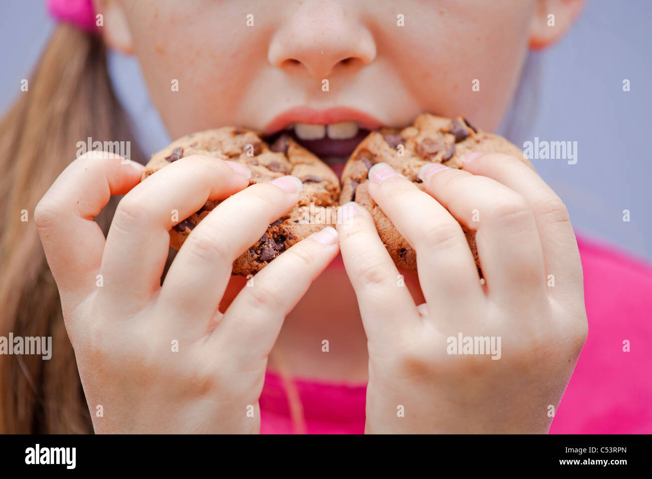 ein sieben-jährige Mädchen essen Schokolade cookies Stockfoto