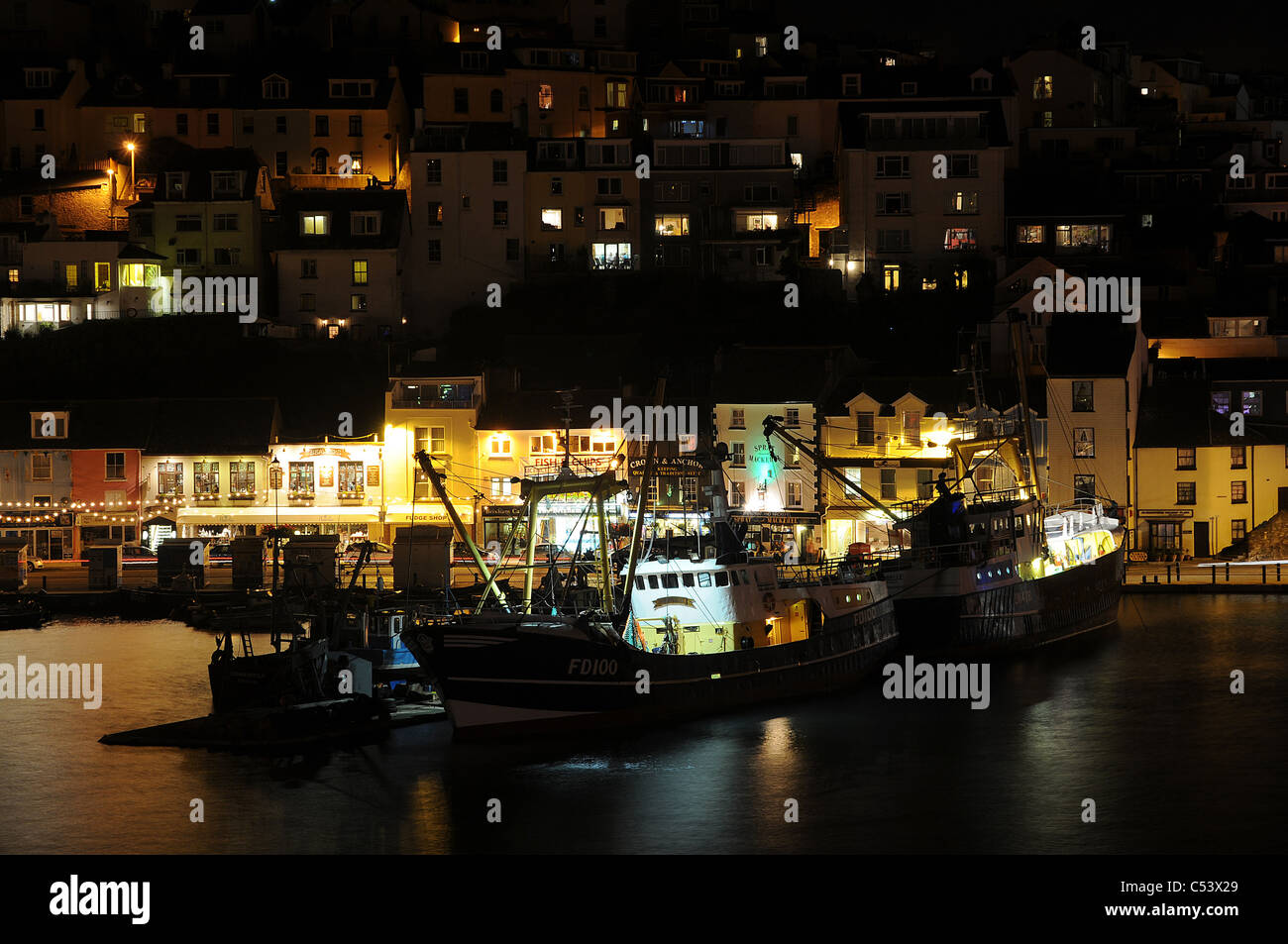 Beleuchteten Fischerboote im Hafen von Brixham bei Nacht. Devon, Großbritannien Stockfoto