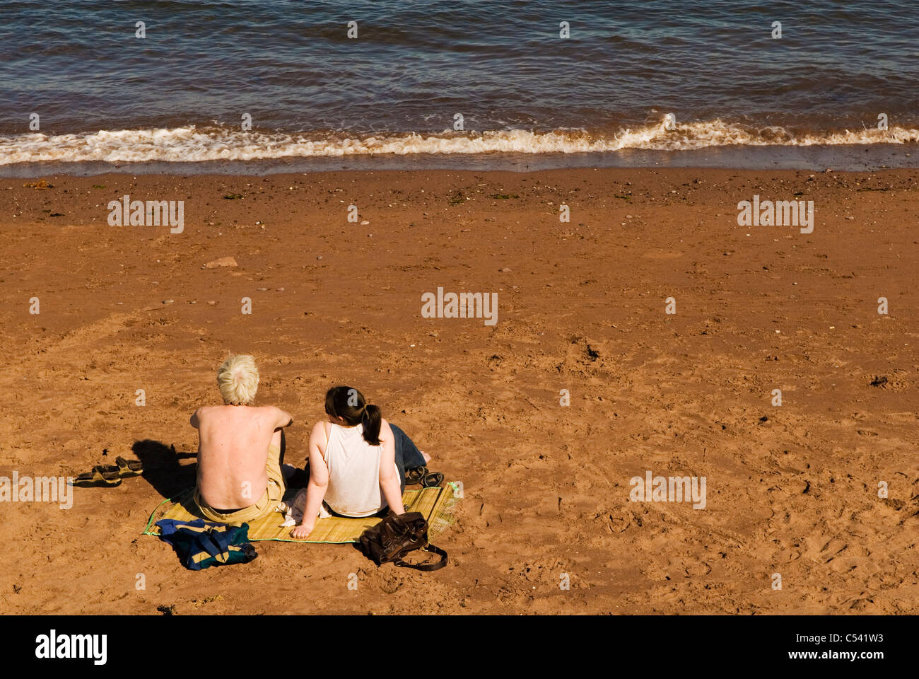 Zwei Sonne Badende mit Blick aufs Meer, UK Stockfoto