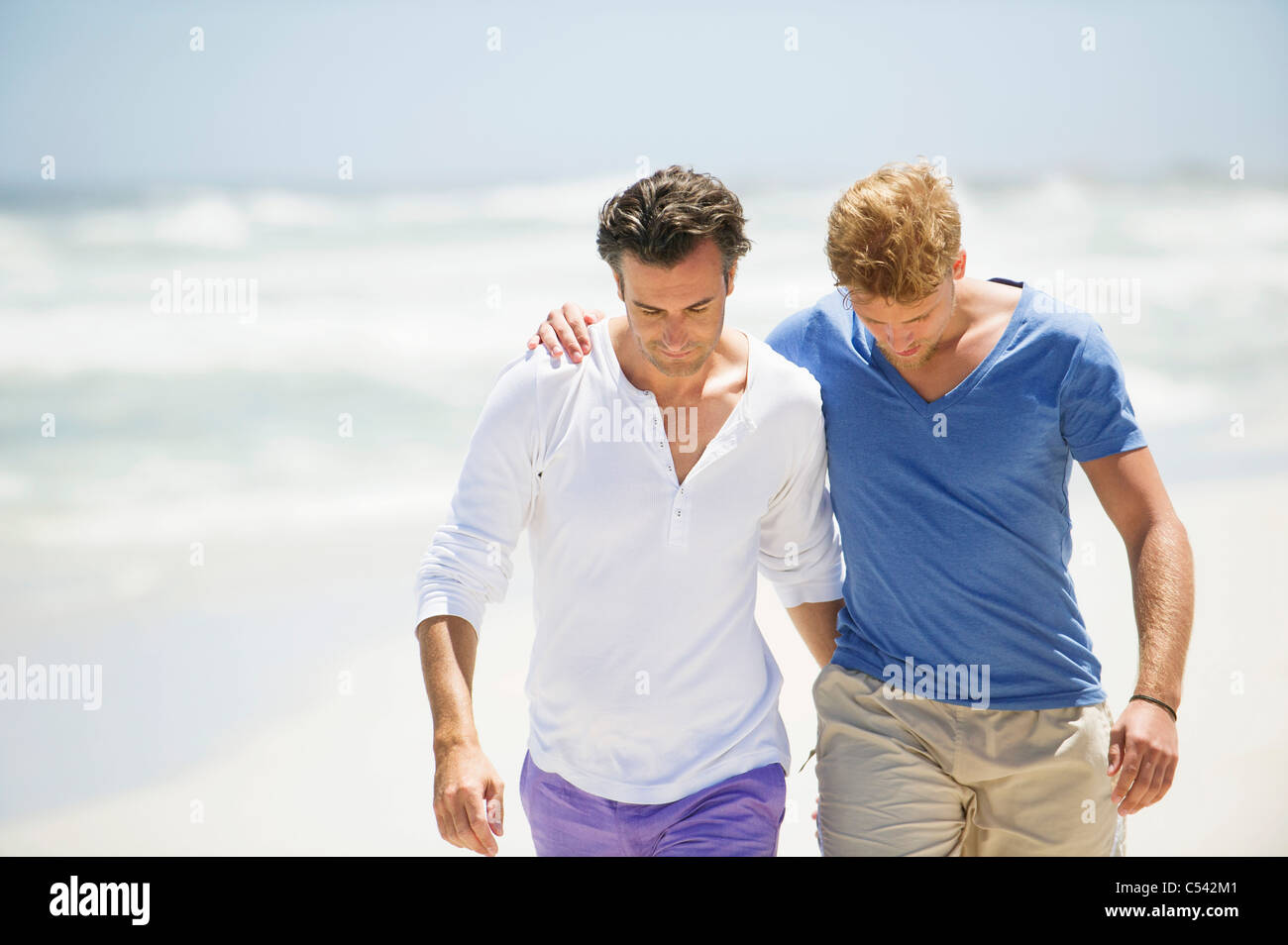 Zwei Männer zu Fuß am Strand Stockfoto