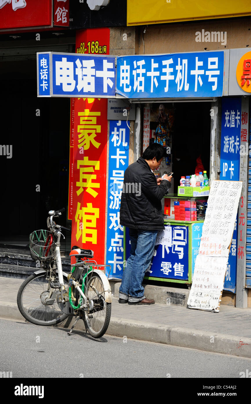 Ein chinesischer Mann mit einem Mobiltelefon in der alten Stadt Shanghai Stockfoto