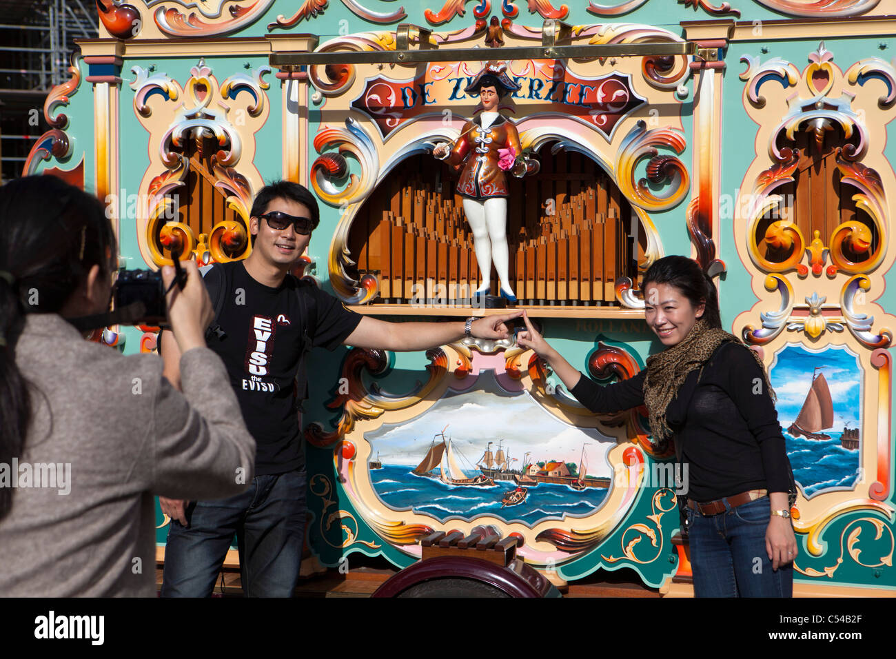 Die Niederlande, Amsterdam, jährliche Parade der Drehorgeln auf dem Dam. Asiatische Touristen, Mann und Frau, Bild genommen haben. Stockfoto