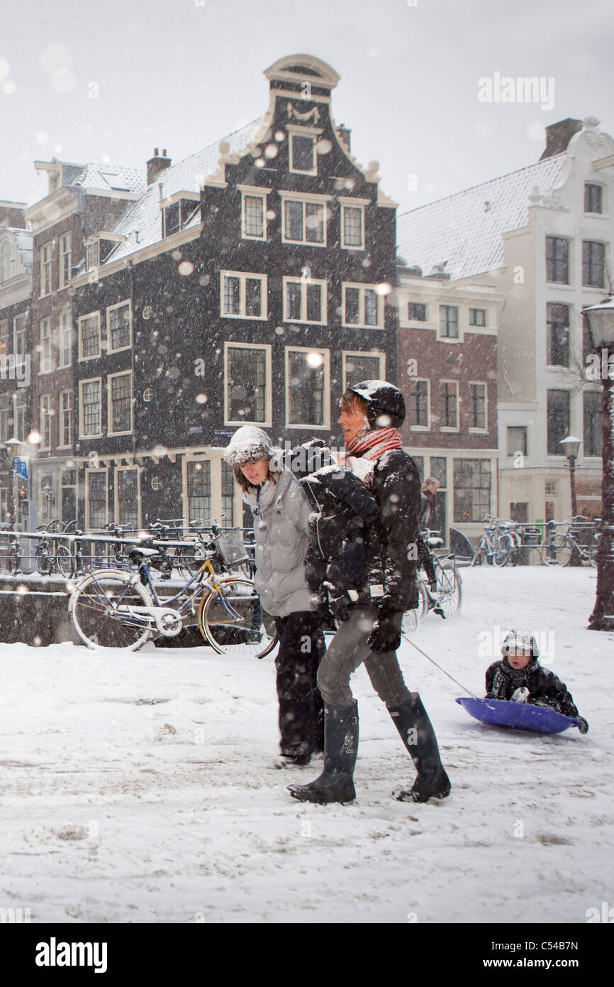 Niederlande, Amsterdam, Winter, Schnee. Frauen mit Kind auf Schlitten. Stockfoto