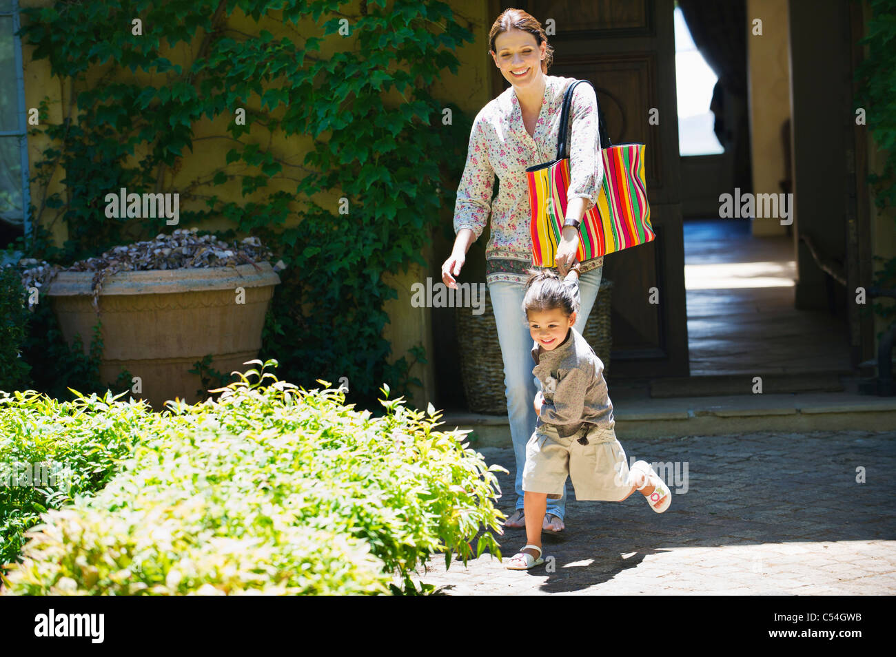 Frau Und Madchen Gehen Aus Dem Haus Hand In Hand Stockfoto Bild