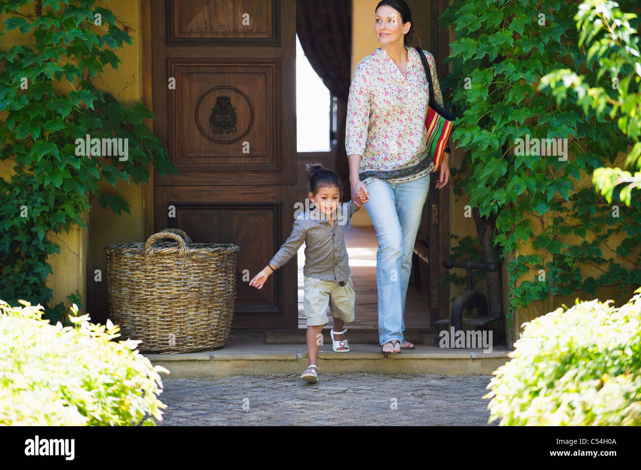Frau Und Madchen Gehen Aus Dem Haus Hand In Hand Stockfoto Bild