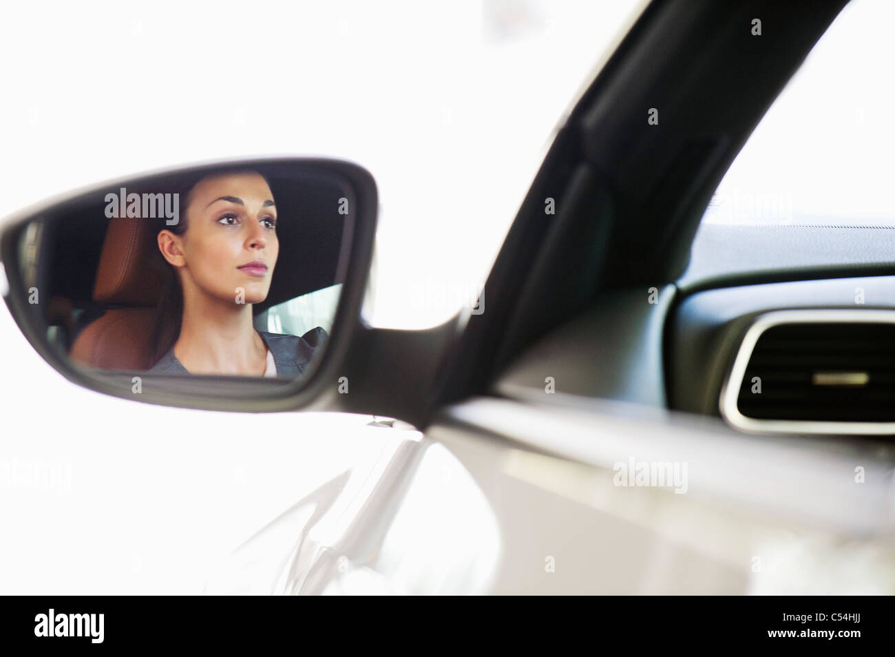 Reflexion einer jungen Frau auf Seitenscheiben des Fahrzeugs während der Einnahme einer Probefahrt Stockfoto