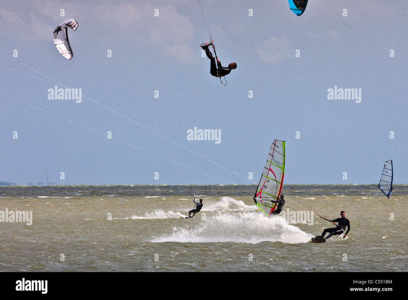 Die Niederlande, in der Nähe von Bakhuizen, Windsurfer und Kitesurfer auf See genannt IJsselmeer. Stockfoto