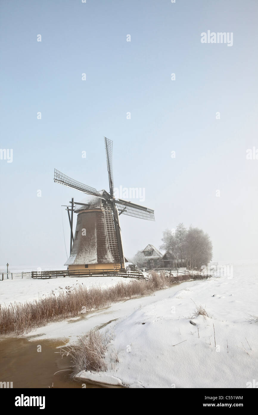 Die Niederlande, Workum, Windmühle in Schneelandschaft. Stockfoto