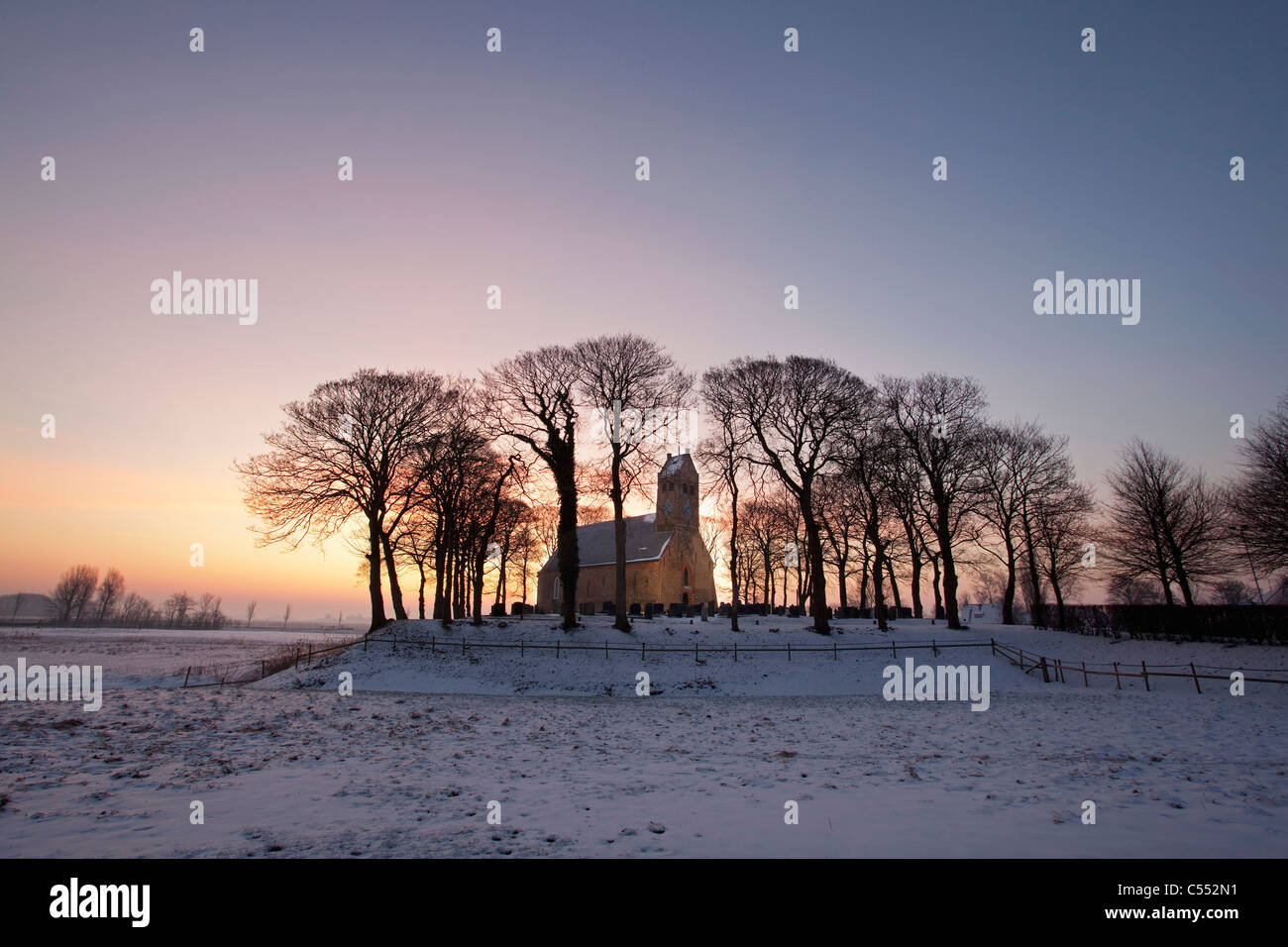 Die Niederlande, Hijum, Kirche auf Hügel im Schnee. Stockfoto
