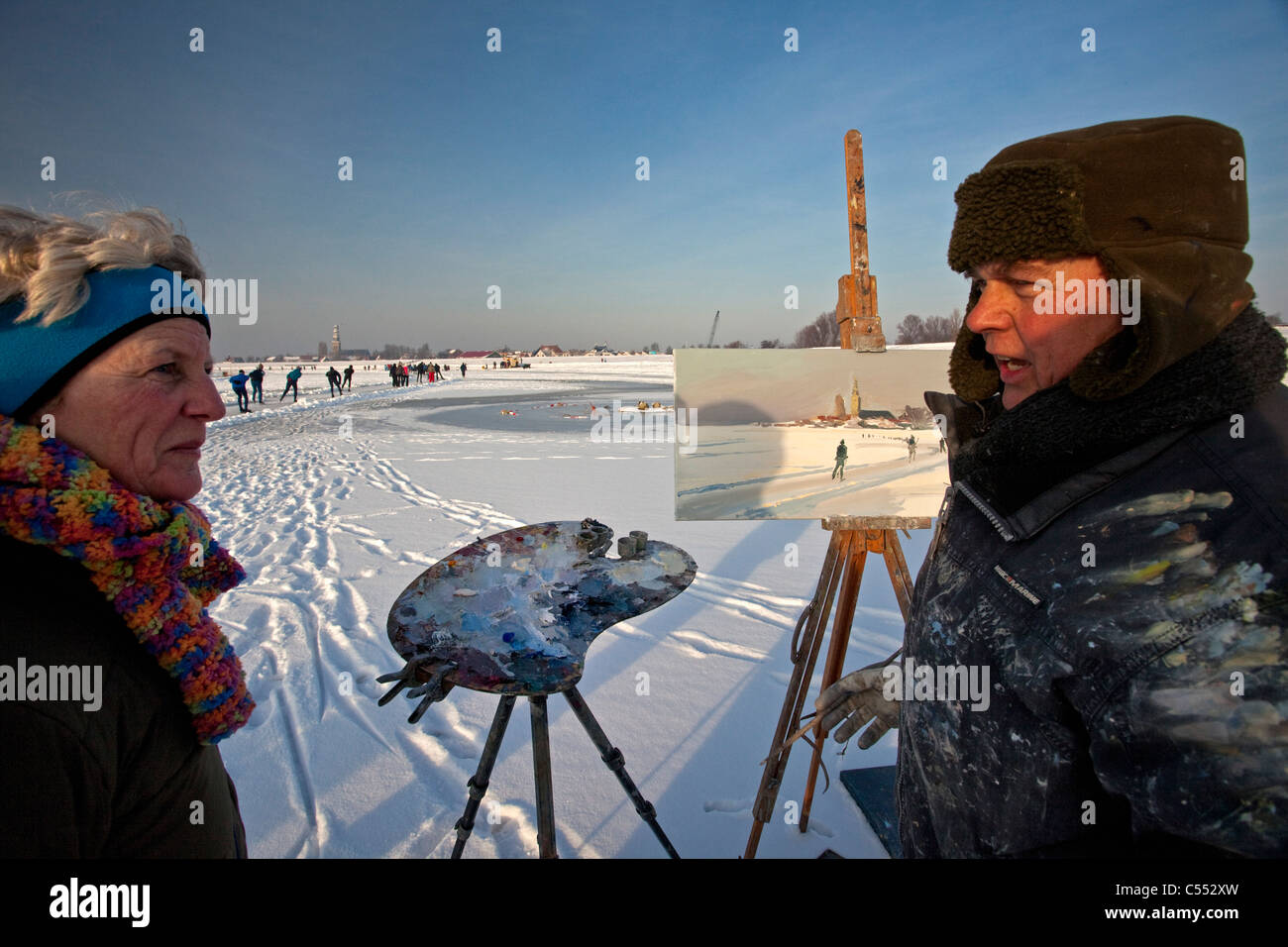 Hindeloopen, niederländische Hauptstadt skating Kultur. Maler, Künstler Gosse Koopmans Malerei der Ice skating Szene bei minus 10 Grad Celsius. Stockfoto
