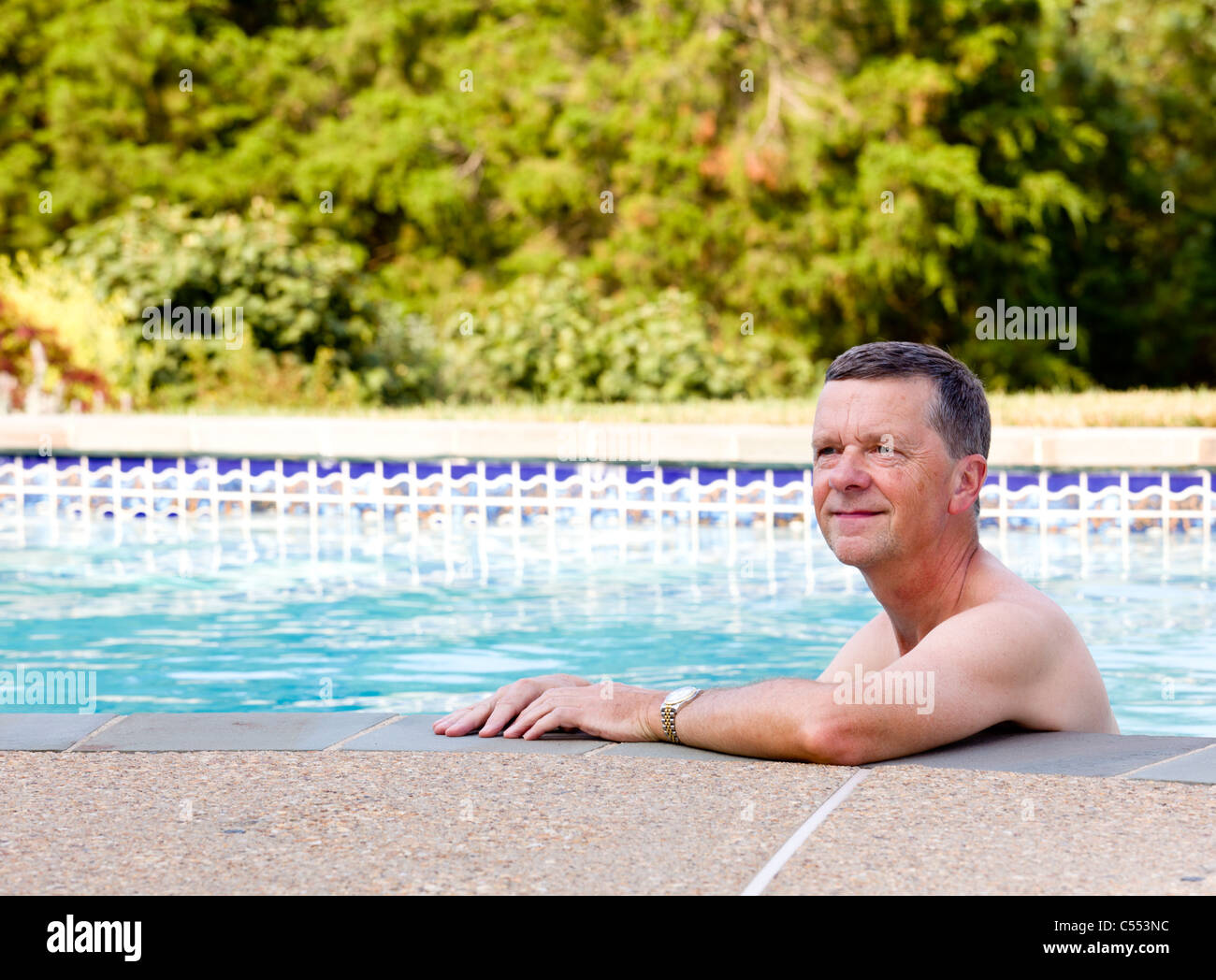 Alter / Senioren Mittelsmann im Swimmingpool im Hinterhof-Garten Stockfoto