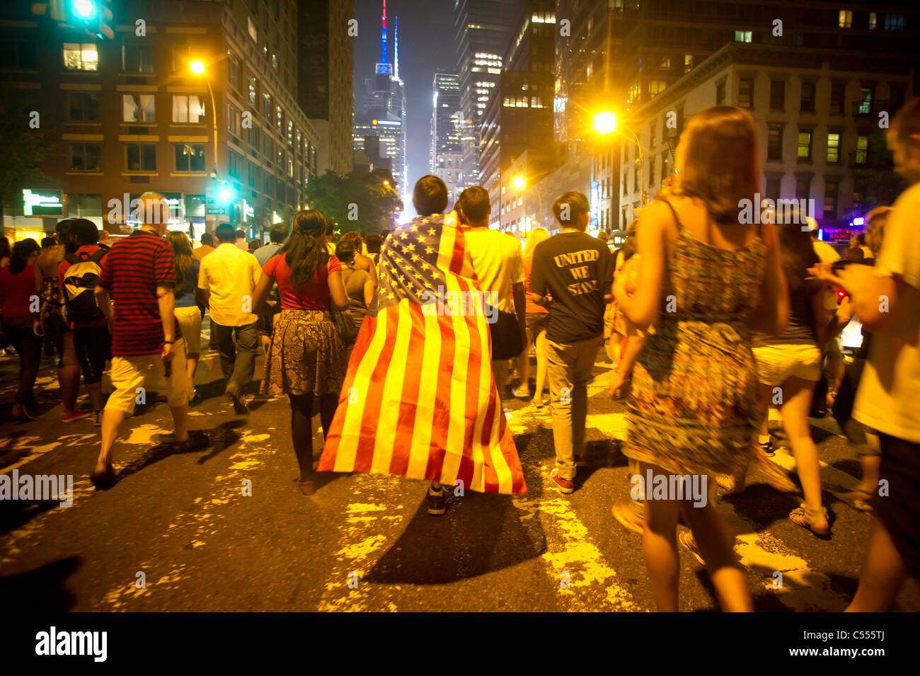 Ein Zuschauer tragen eine amerikanische Flagge verlässt nach der 35. jährlichen Macy Fourth Of July Feuerwerk in New York anzeigen Stockfoto