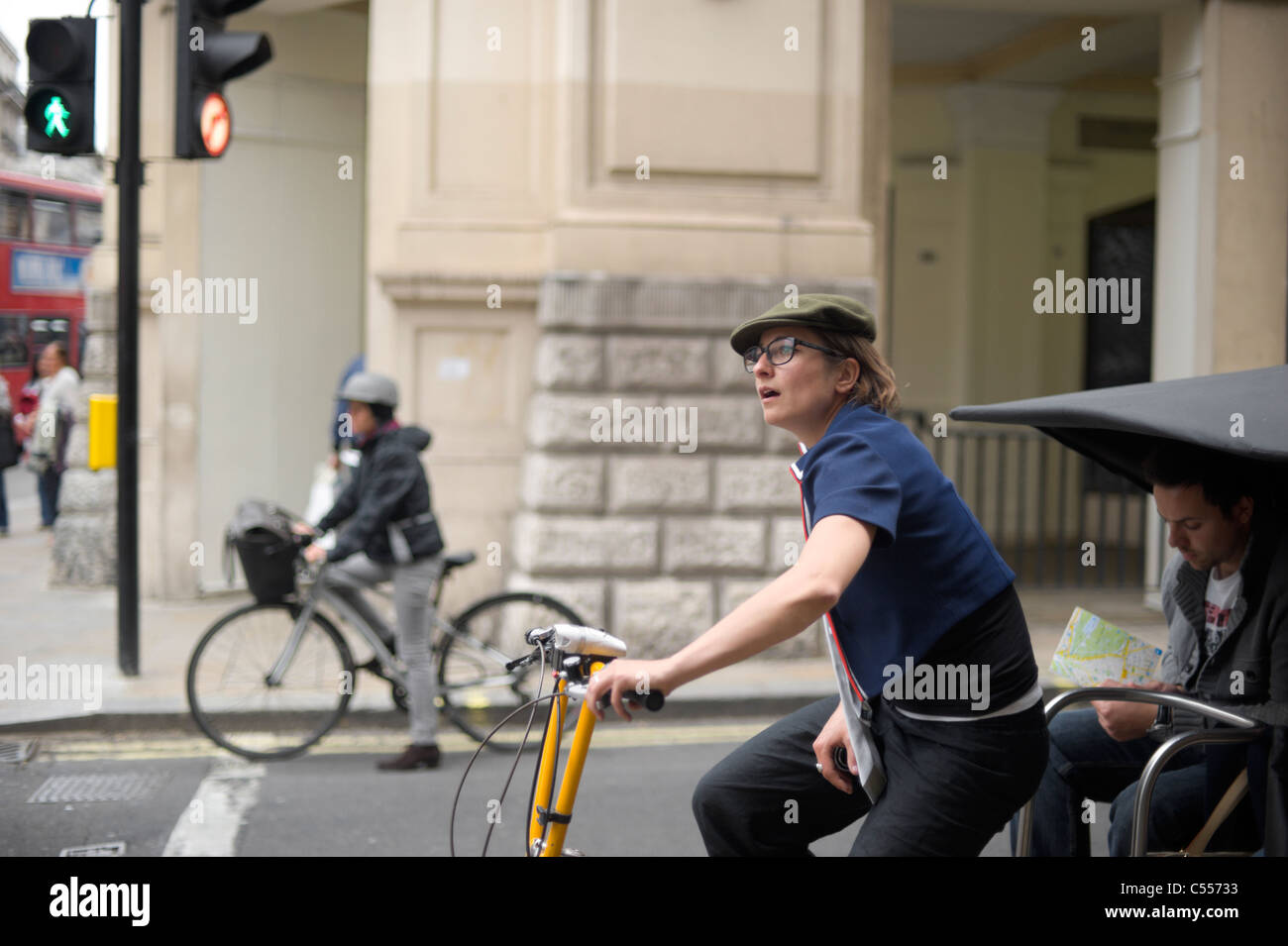 Frau-Zyklus-Rikscha-Fahrer warten an der Ampel in der Nähe von Piccadilly Circus Stockfoto