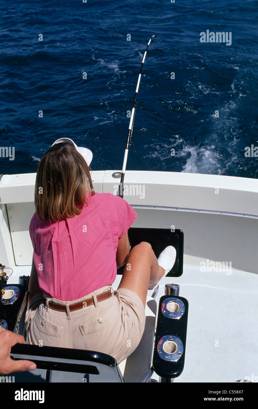 Rückansicht einer Frau im Meer auf einem Boot Angeln Stockfoto