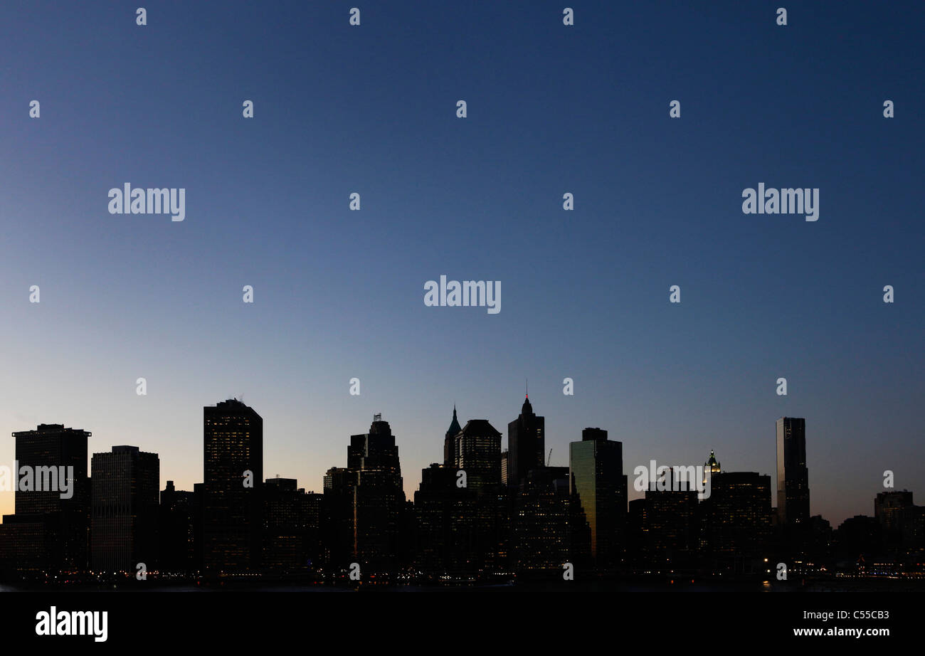 Eine Silhouette der Innenstadt von Manhattan, New York City, entnommen aus Brooklyn Heights in der Abenddämmerung Stockfoto