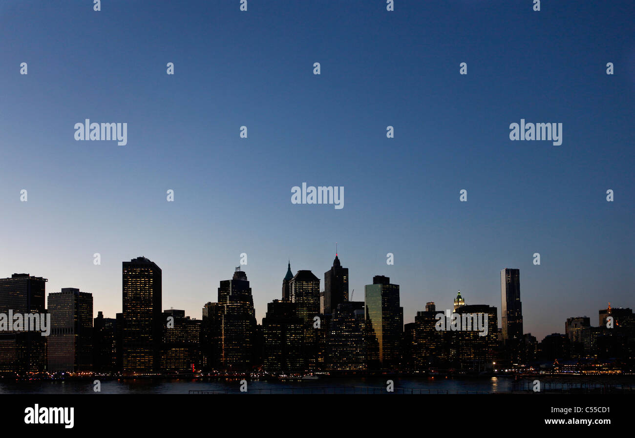 Eine Silhouette der Innenstadt von Manhattan, New York City, entnommen aus Brooklyn Heights in der Abenddämmerung Stockfoto