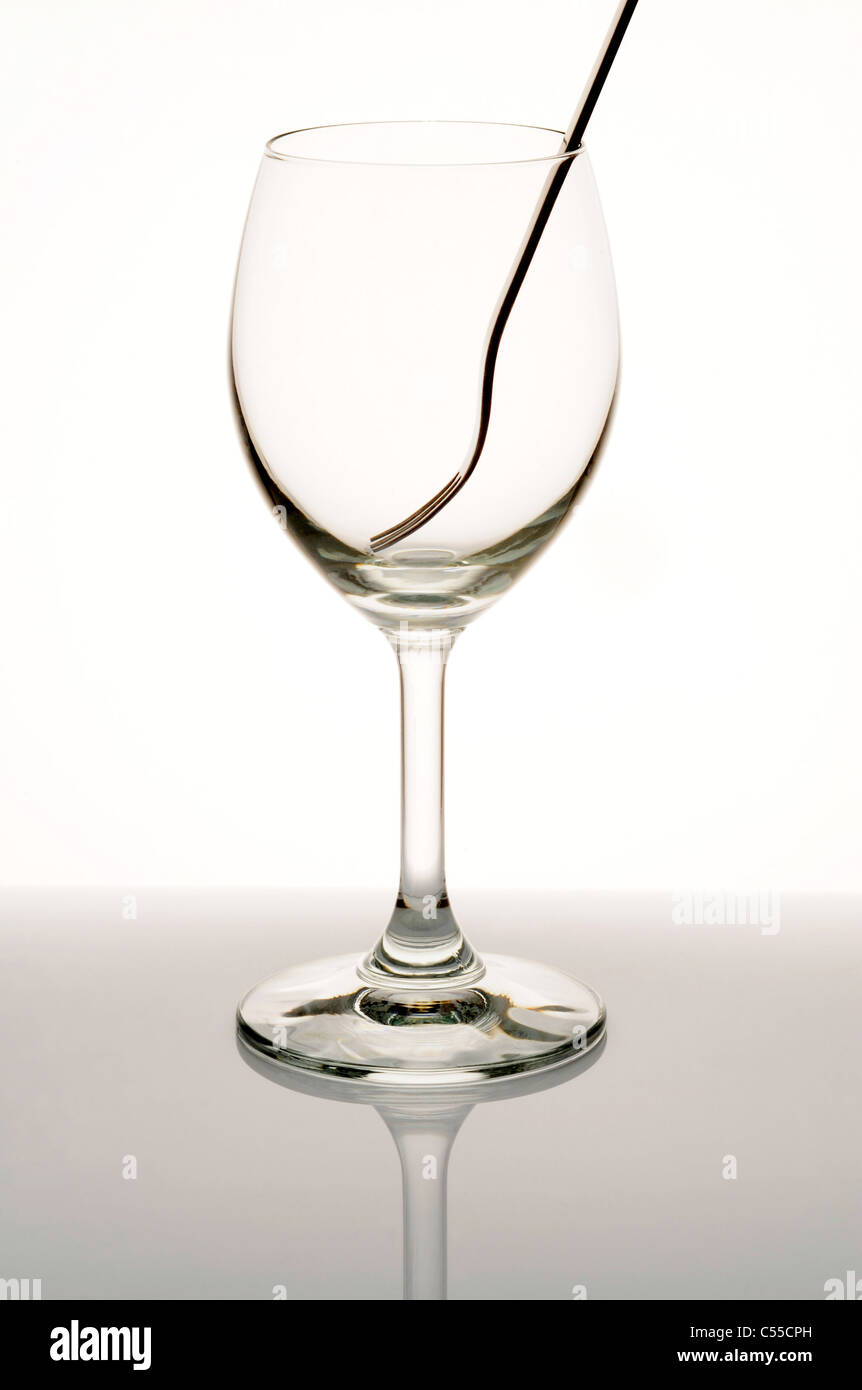 Weinglas und Gabel auf weißem Hintergrund Stockfoto
