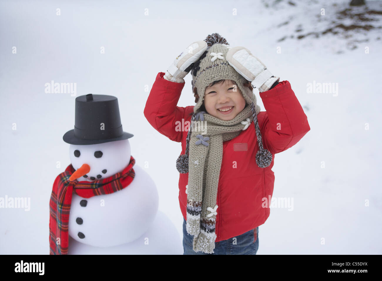 Ein Kind und ein Schneemann Stockfoto