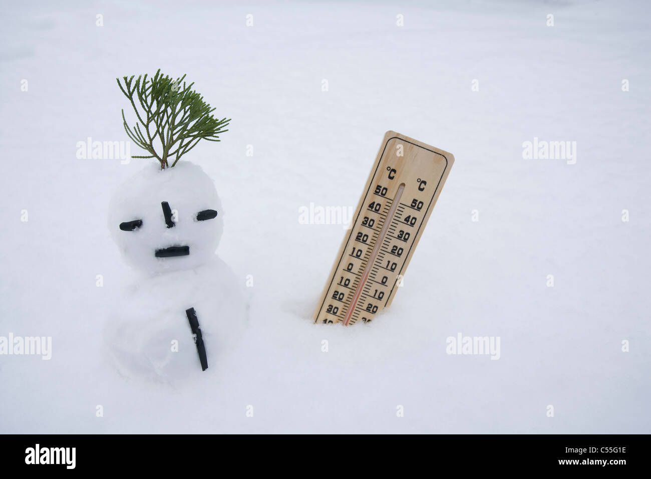 Schneemann und Temperatur auf Schneefeld Stockfoto