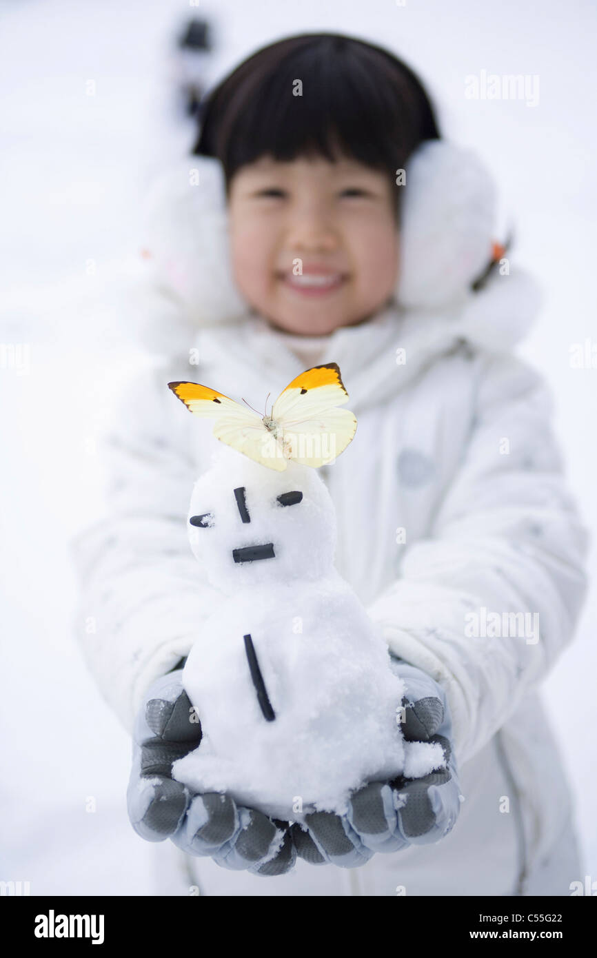 ein Mädchen hat einen Schneemann mit Schmetterling Stockfoto
