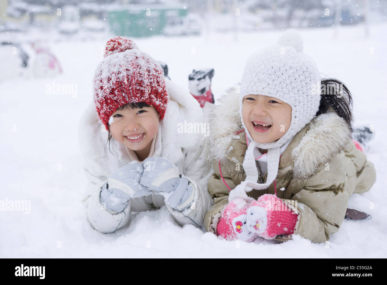 Mädchen legen Sie Gesicht auf Schneefeld Stockfoto
