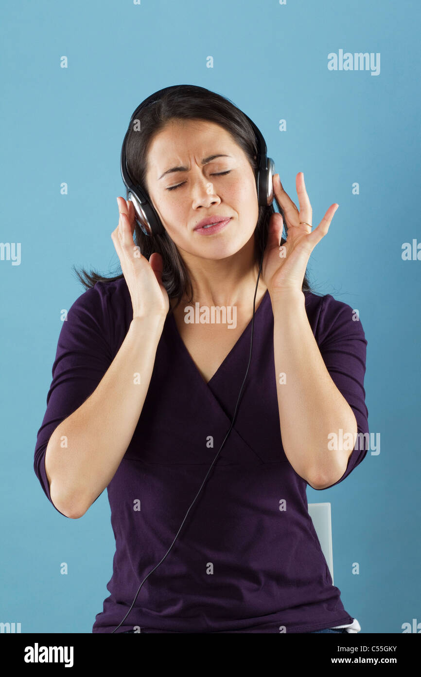 Junge Frau mit Kopfhörern Musik hören Stockfoto
