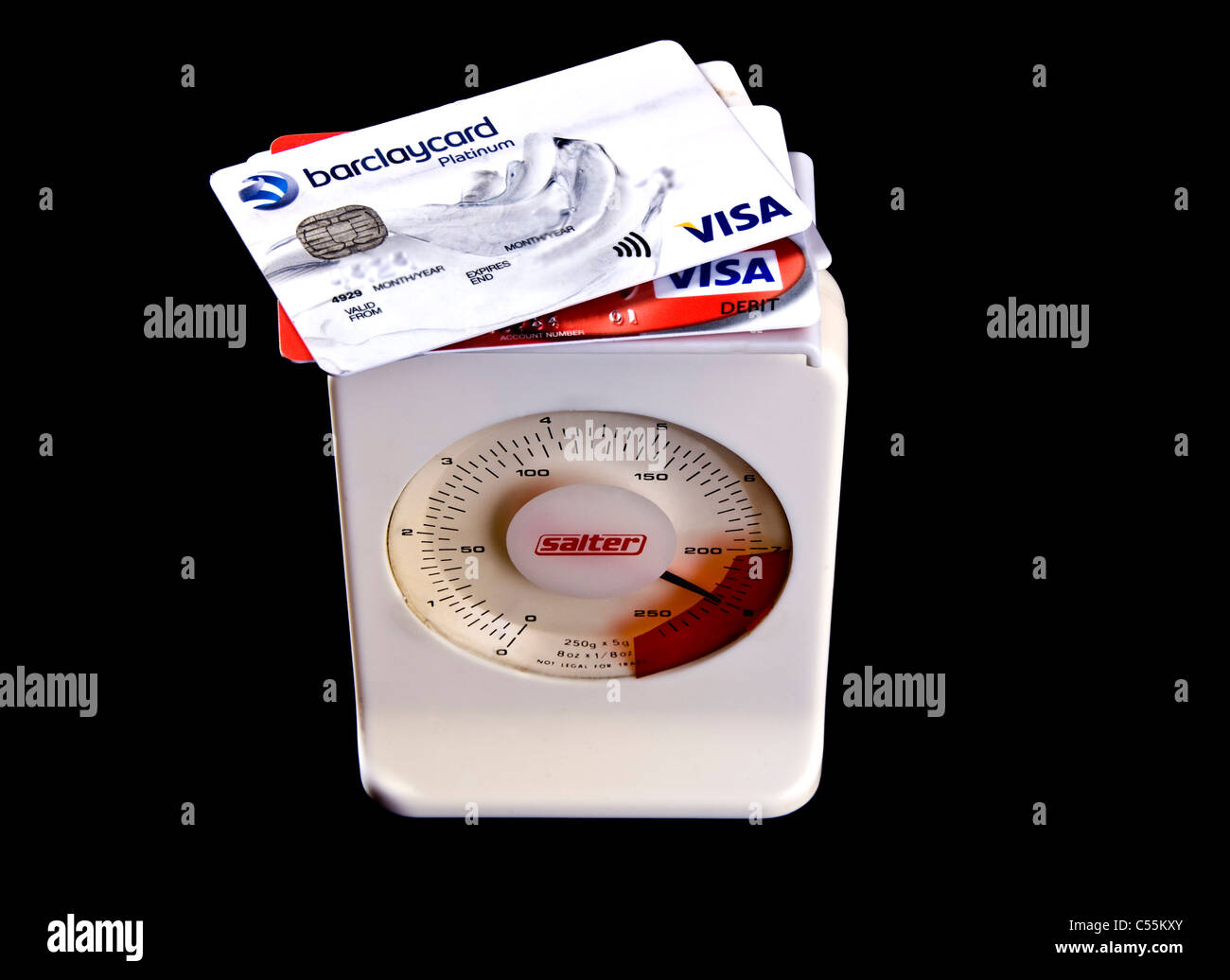 Kreditkarten auf Skalen, schwer mit Schulden gehen in die roten Zahlen. Stockfoto