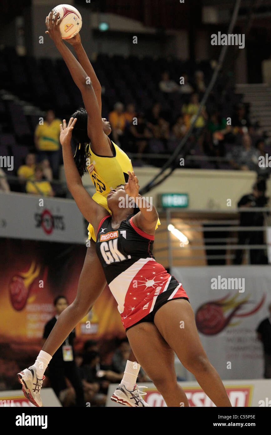 08.07.2011 schlägt Romelda Aiken von Jamaica(yellow) Alicia Liverpool den Ball während des Viertelfinales zwischen Jamaika und Trinidad & Tobago, Mission Foods Netball Weltmeisterschaften 2011 vom Singapore Indoor Stadium in Singapur. Stockfoto