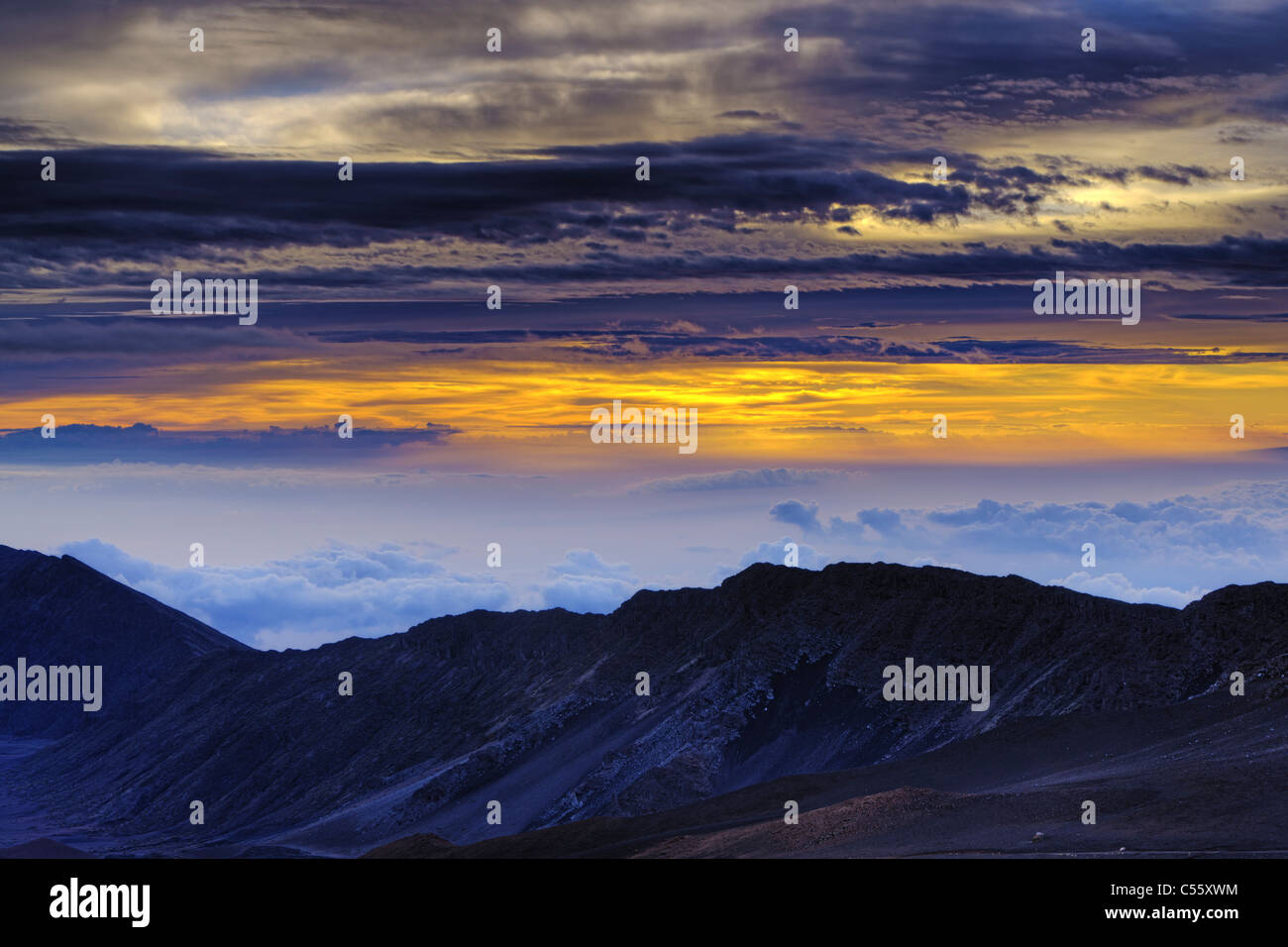 Wolken über den Bergen bei Sonnenaufgang, Haleakala, Maui, Hawaii, USA Stockfoto