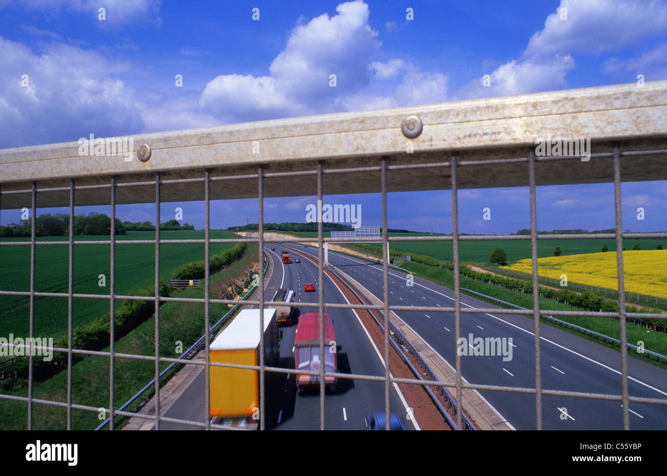 Blick hinunter auf den Verkehr durch Schutzzaun auf Brücke über die Autobahn A1/M in der Nähe von Leeds Yorkshire UK Stockfoto