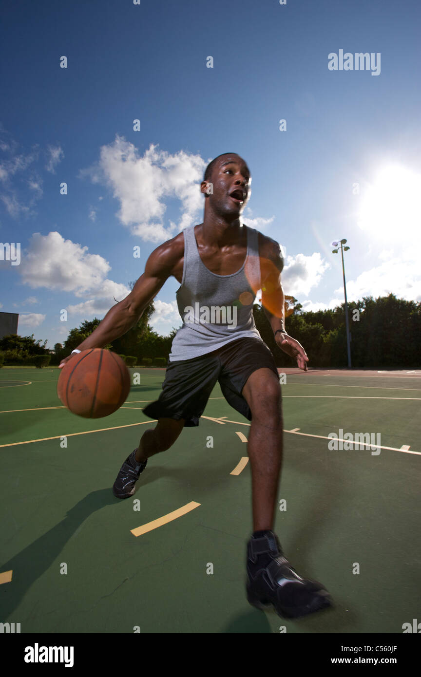 Mann fahren zum Korb auf Freiplatz Stockfoto