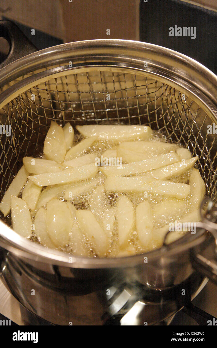 Hausgemachte Chips König Edward Kartoffeln kochen in sprudelnden heißen Pflanzenöl in einer Pfanne Chip in UK Küche Stockfoto