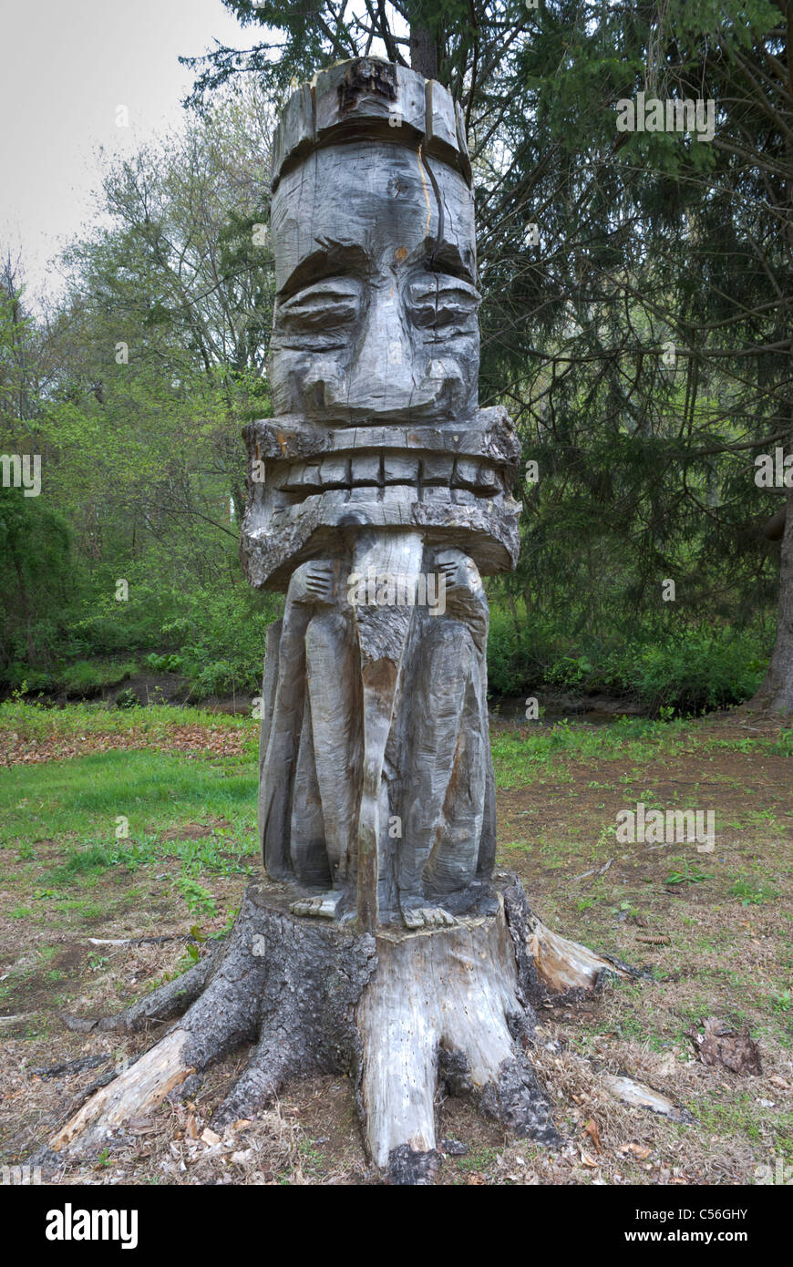 Eine kreative Schnitzer hat eine ungewöhnliche Totem aus einem alten Baumstumpf in Berkley, Massachusetts. Stockfoto