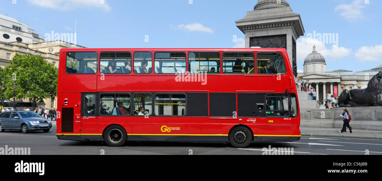London West End street scene Seitenansicht des rot markierten öffentlichen Verkehrsmitteln Double Decker London Bus vorbei an Nelsons Column in Trafalgar Square England Großbritannien Stockfoto