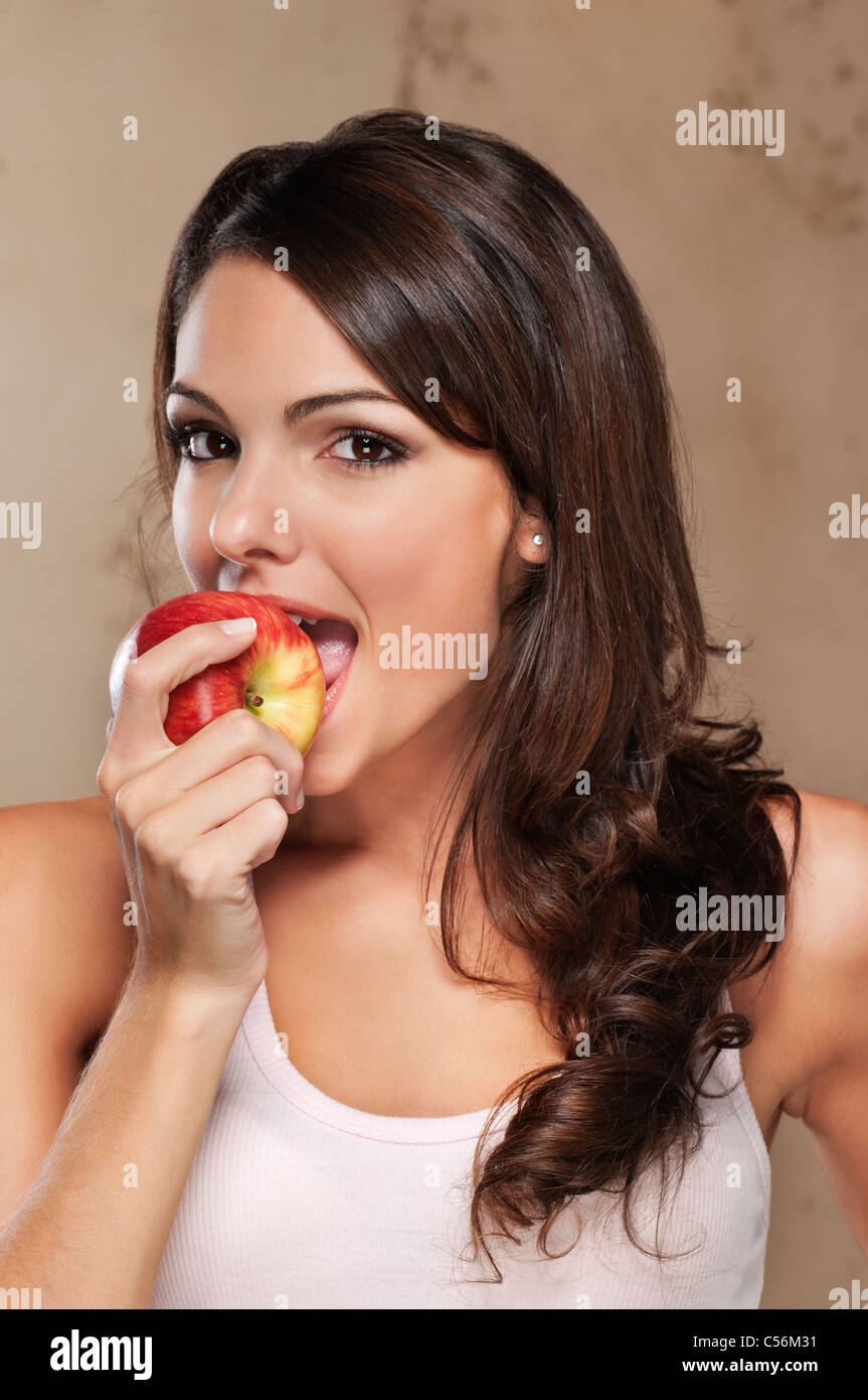Close-up Portrait einer attraktiven Frau einen Apfel essen Stockfoto