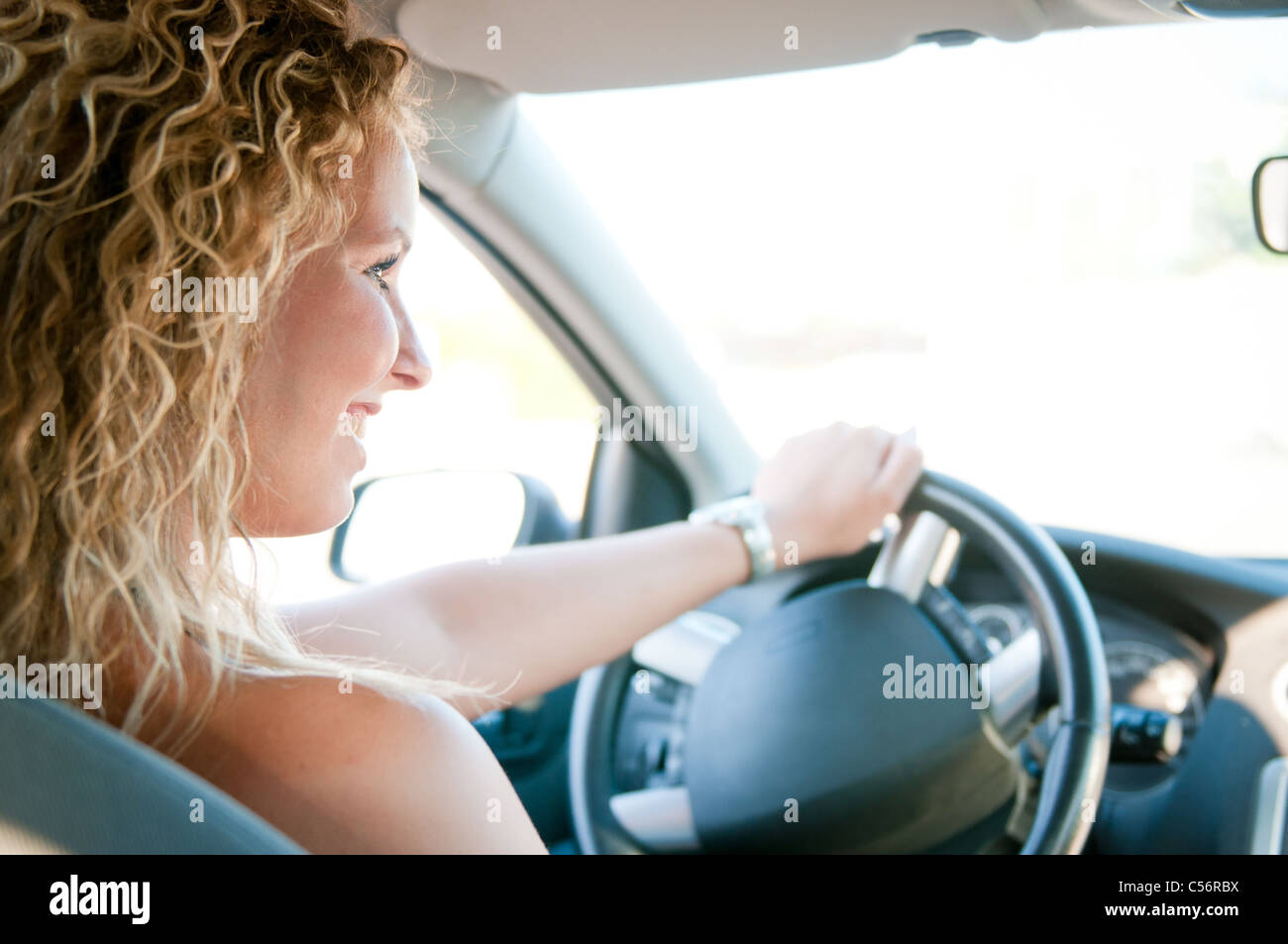 Porträt des jungen lächelnde Frau, die Auto fahren Stockfoto