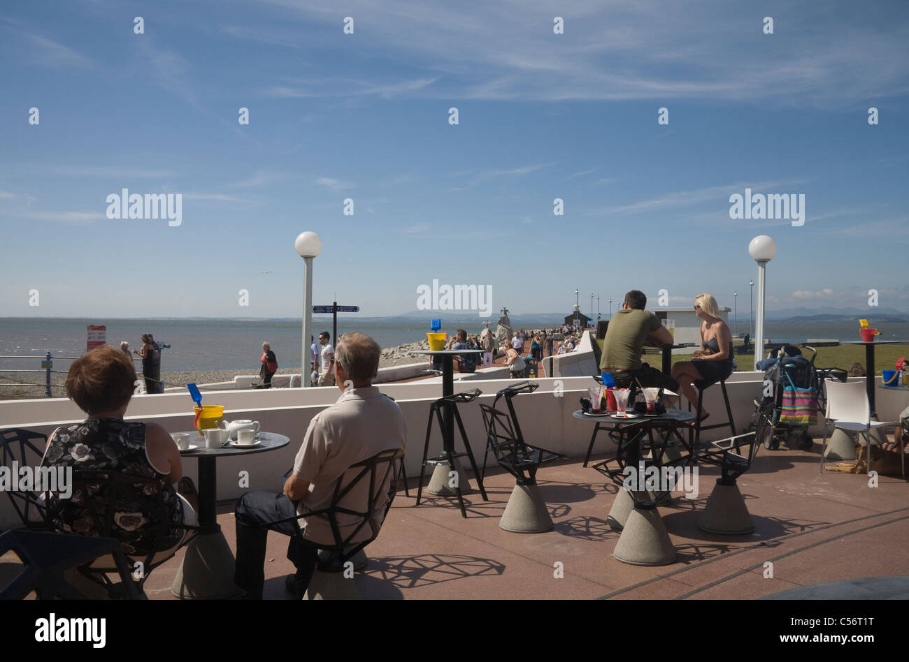 Morecambe Lancashire England UK Urlauber sitzen in einem Straßencafé mit Refreshmants Blick auf Stein Steg Stockfoto