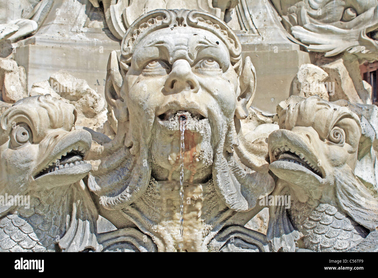 Brunnen mit einem männlichen Kopf spucken Wasser blickte zum Himmel und eine Fisch-Figur auf jeder Seite Stockfoto