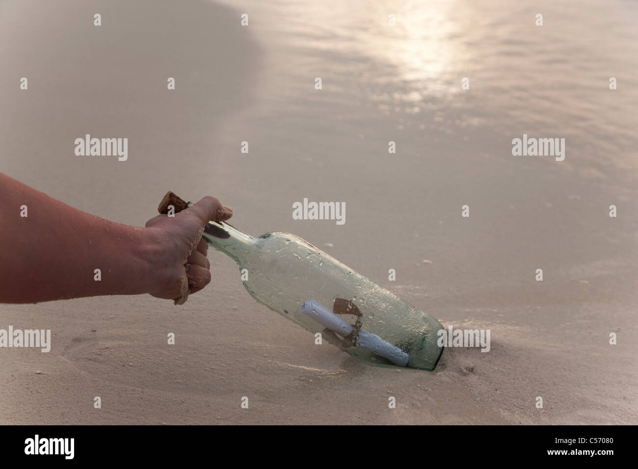 Person mit eine Flaschenpost am Strand Stockfoto