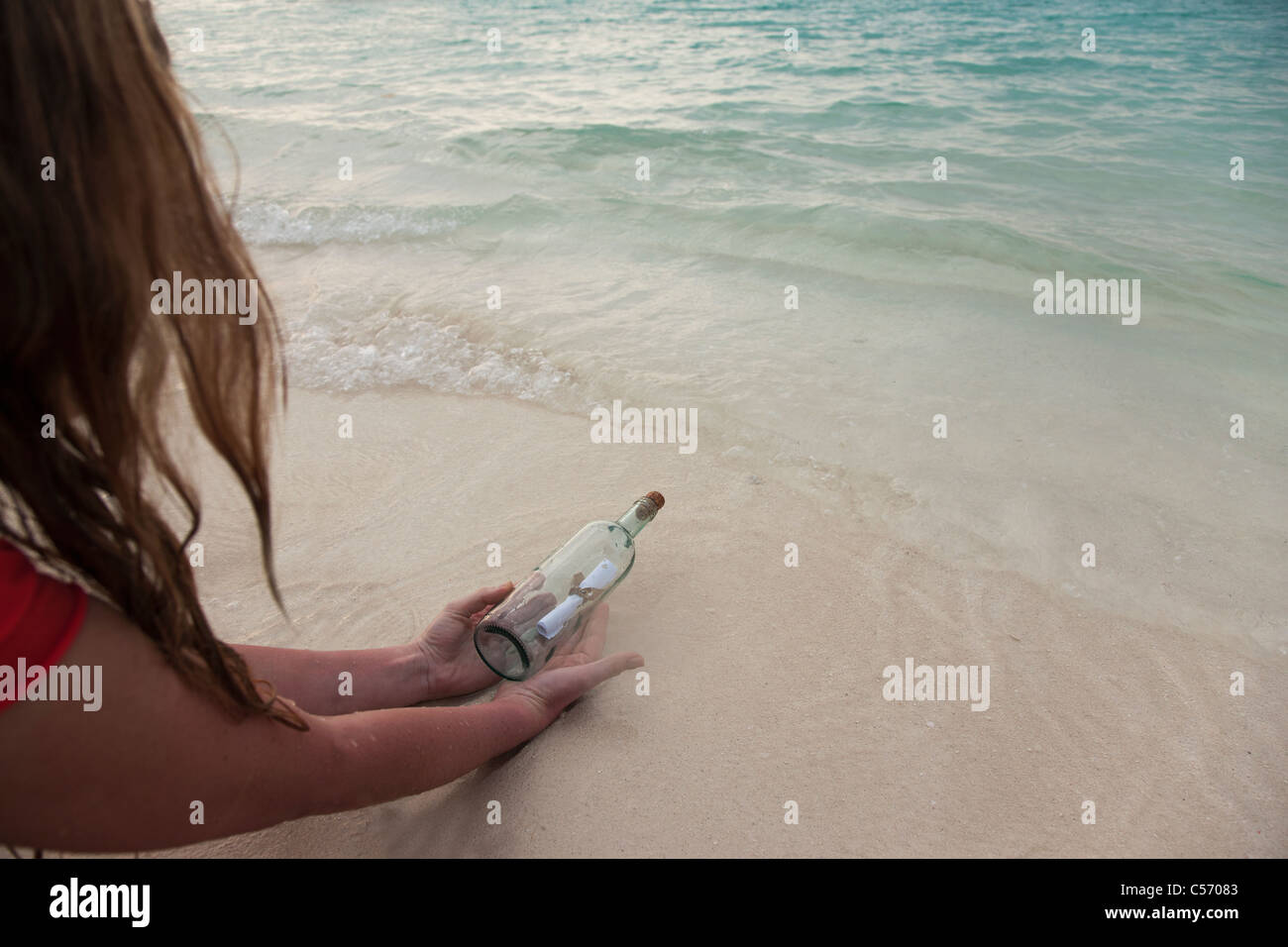 Frau mit eine Flaschenpost am Strand Stockfoto