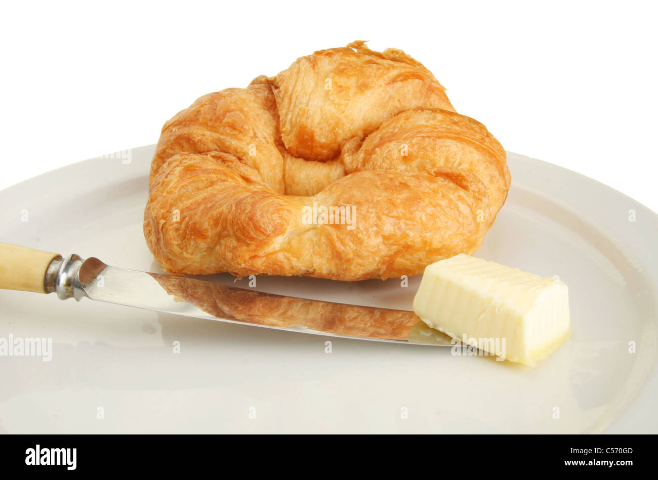 Croissant-Messer und Butter auf einem Teller Stockfoto