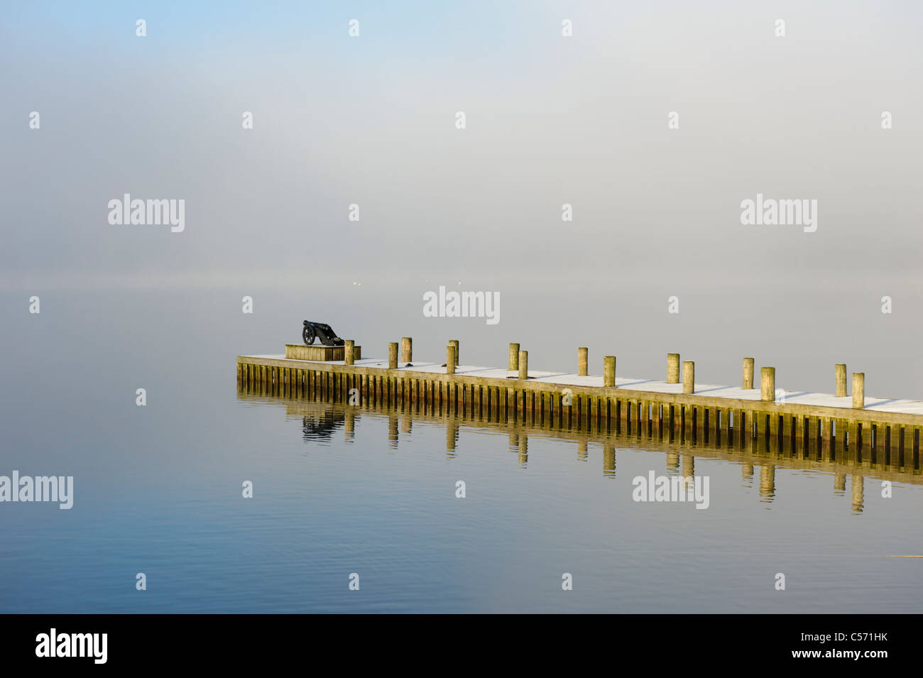 Kanone am Ende der Mole mit Nebel im Hintergrund über Windermere, Lake District, Cumbria Stockfoto