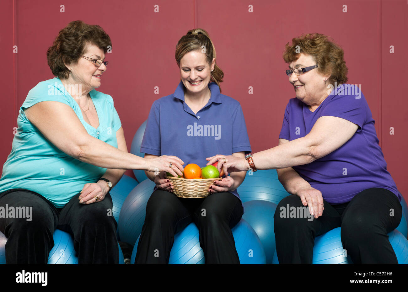 Ältere Frau mit Obst im Fitness-Studio Stockfoto