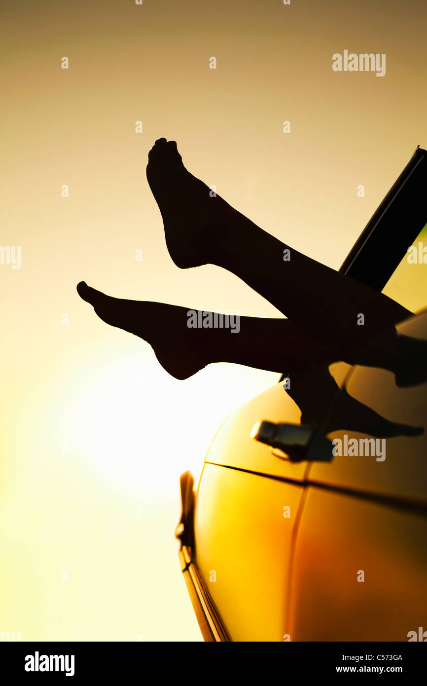 Frau die Füße ragte aus dem Autofenster Stockfoto