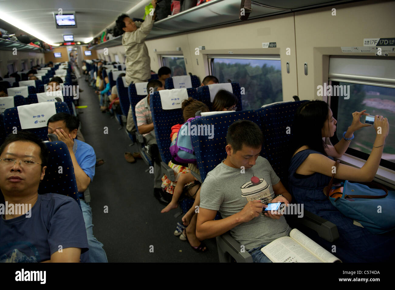 Passagiere sitzen in einem CRH (China Railway High-Speed) Zug Reisen zwischen Shanghai und Peking, in China. 10. Juli 2011 Stockfoto