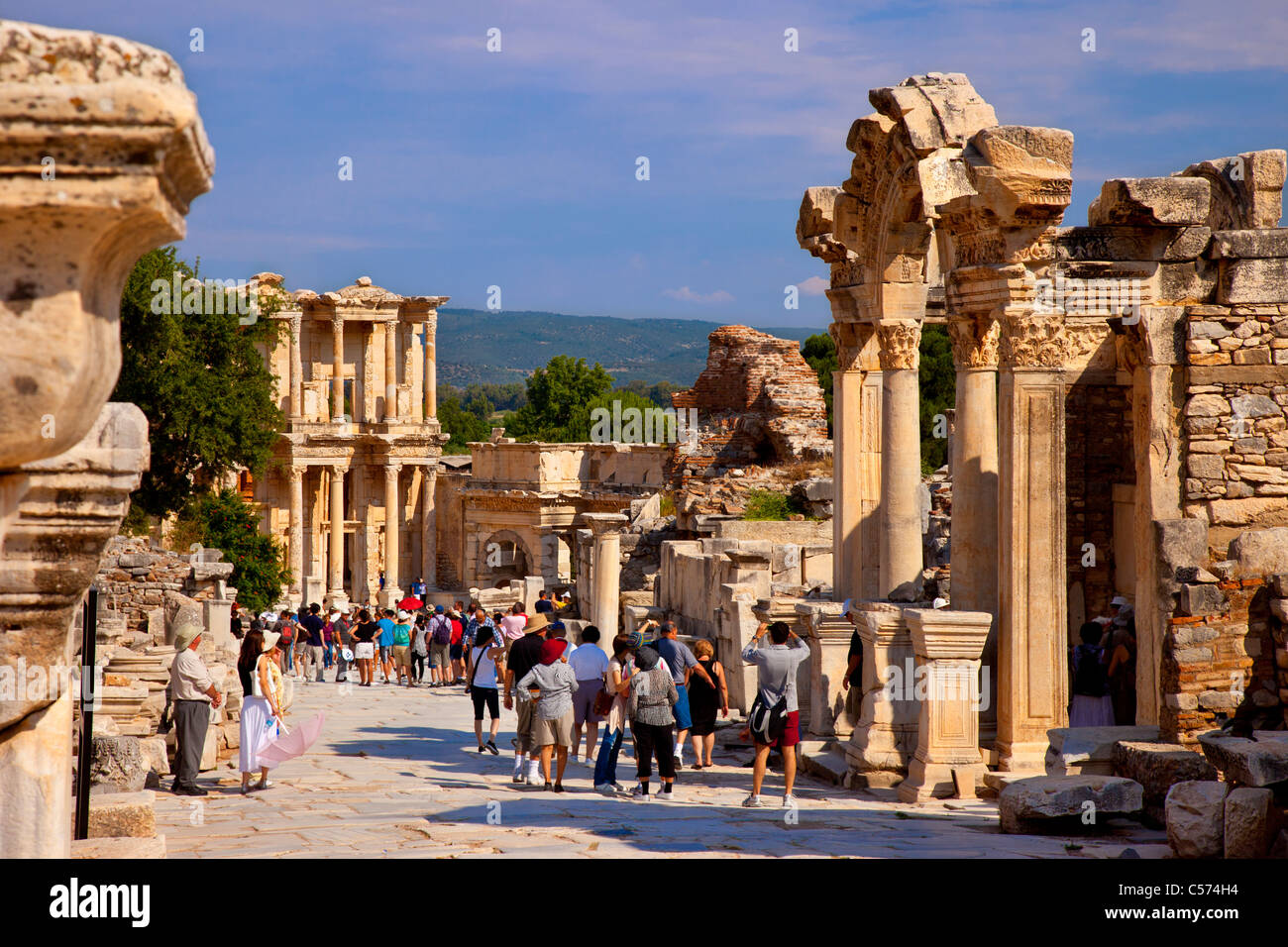Touristen spazieren durch die mit Marmor gepflasterte Straße von Curetes in der Nähe des Hadrian-Tempels und der Celsus-Bibliothek in Ephesus, Türkei Stockfoto